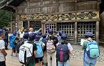 Student group in front of Toshogu Shrine entrance with guide gesturing toward architecture